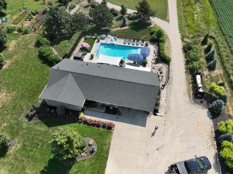 The finished roof from above, with new charcoal shingles and the yard and driveway cleared of every scrap
