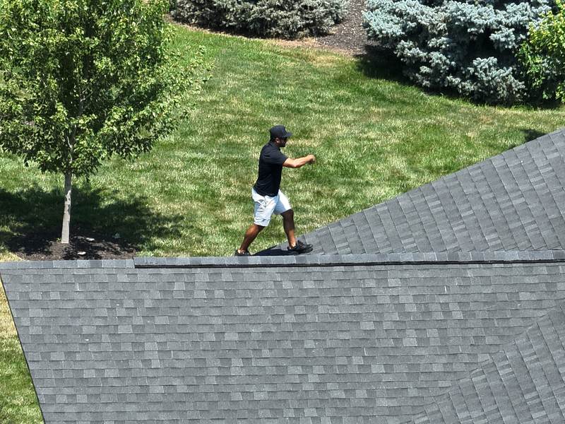 Walking the ridge of a finished roof during a hands-on inspection